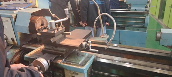 張明見在進行車削加工。